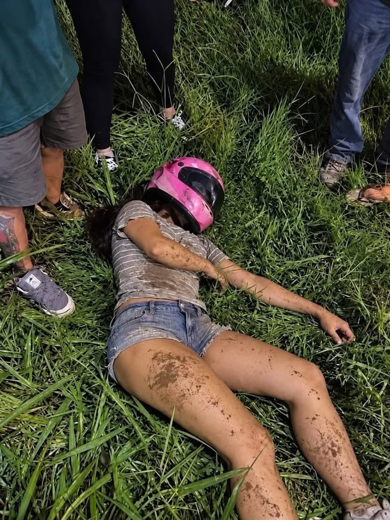 Una mujer con casco rosa aparece tendida junto a una carretera y la imagen genera preocupación en redes