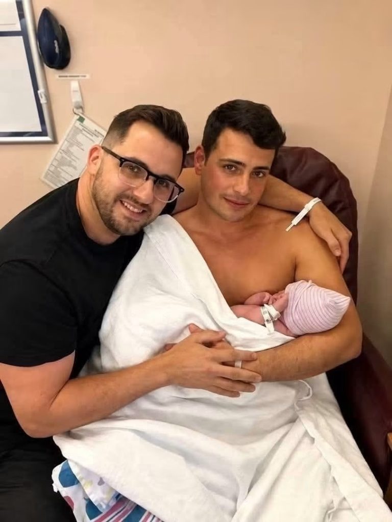 Una foto de dos hombres junto a un recién nacido despierta curiosidad y genera preguntas en las redes sociales